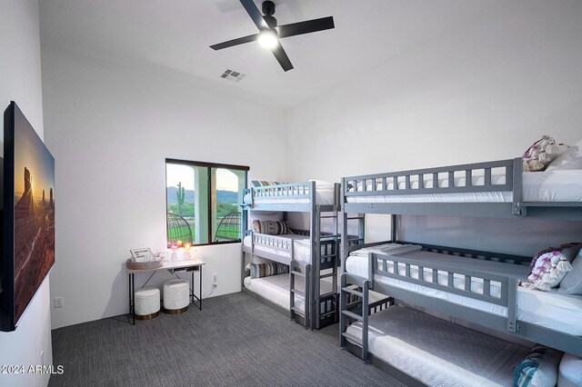 carpeted bedroom with a high ceiling and ceiling fan