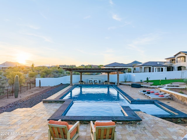 pool at dusk featuring a pergola and a patio area