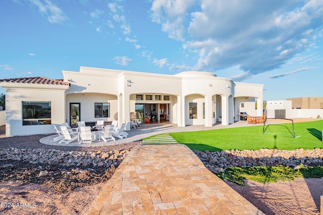 back of house featuring a lawn and a patio area