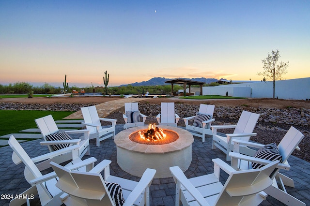 patio terrace at dusk featuring a mountain view, a gazebo, and a fire pit