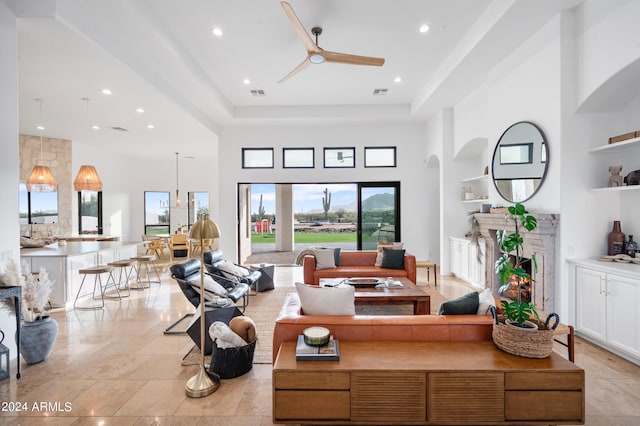 living room with a high ceiling, a premium fireplace, and a raised ceiling