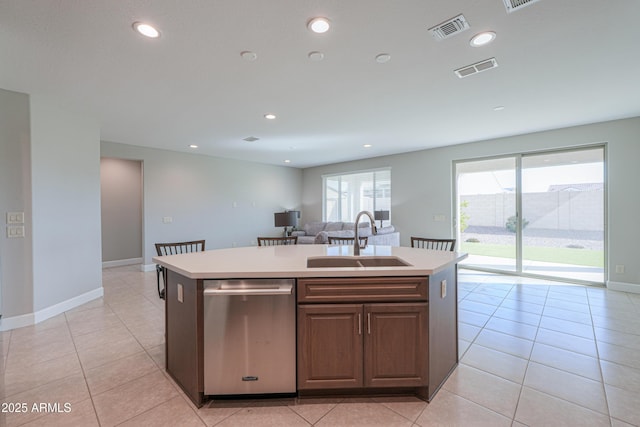 kitchen with a kitchen island with sink, sink, light tile patterned floors, and dishwasher