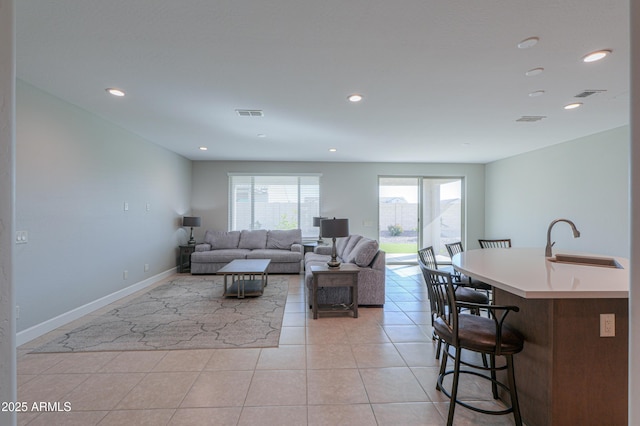 living room featuring sink and light tile patterned floors