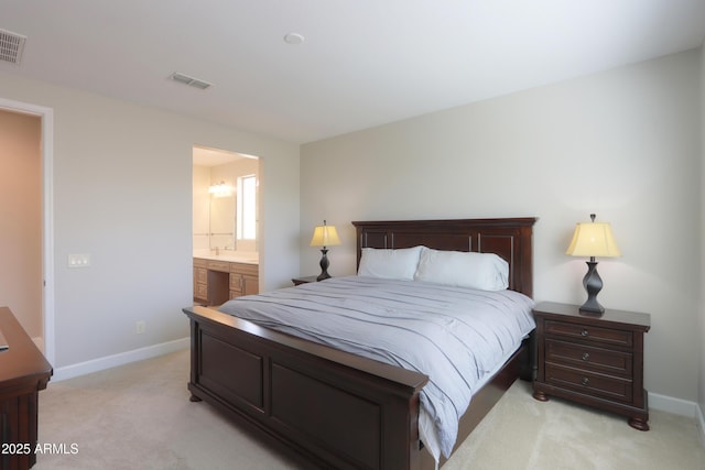 bedroom with light carpet and ensuite bath