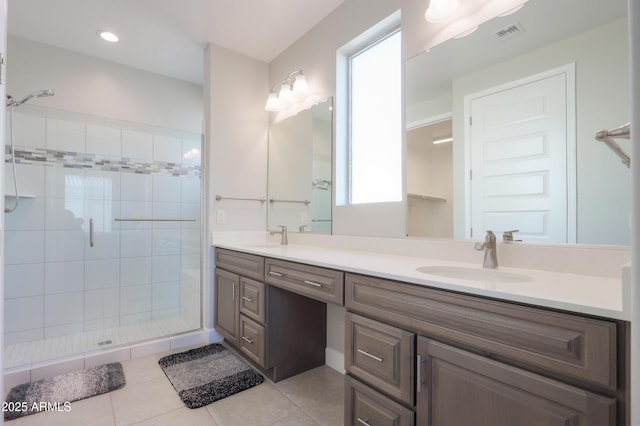 bathroom featuring vanity, tile patterned floors, and tiled shower