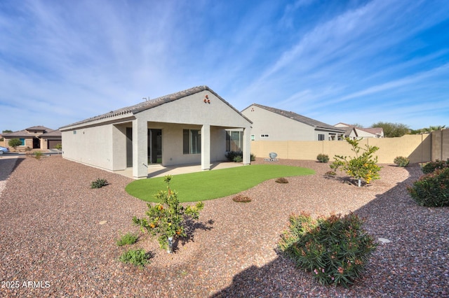 back of house with a lawn and a patio area