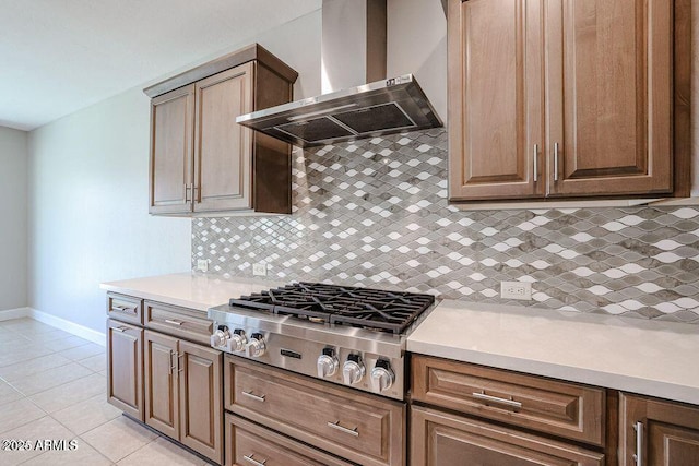 kitchen featuring tasteful backsplash, light tile patterned floors, stainless steel gas cooktop, and wall chimney exhaust hood