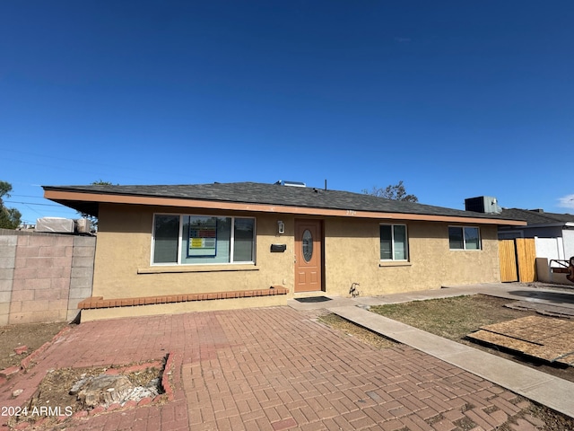 ranch-style house with central air condition unit and a patio