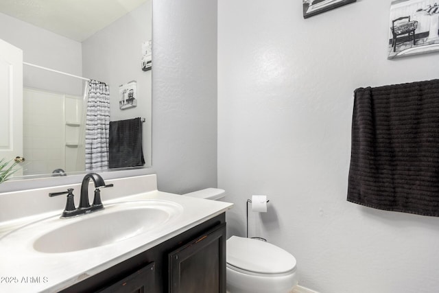 bathroom featuring vanity, curtained shower, and toilet