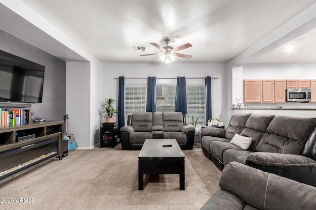 carpeted living room with ceiling fan