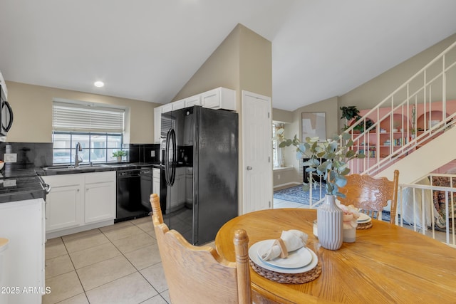 kitchen featuring light tile patterned floors, a sink, white cabinets, black appliances, and dark countertops