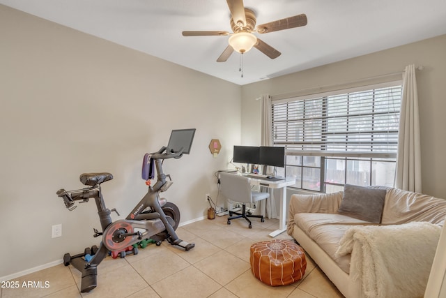 tiled office space featuring ceiling fan and baseboards