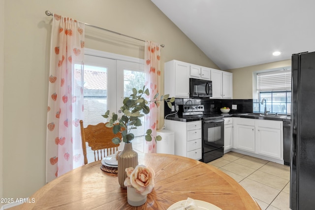 kitchen with black appliances, light tile patterned floors, white cabinetry, and a sink