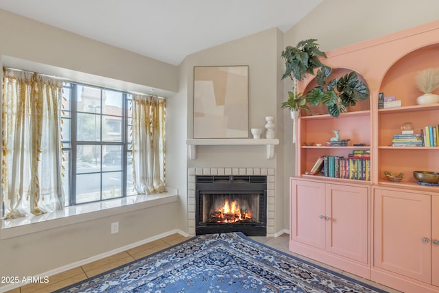 tiled living room with vaulted ceiling and a fireplace with flush hearth