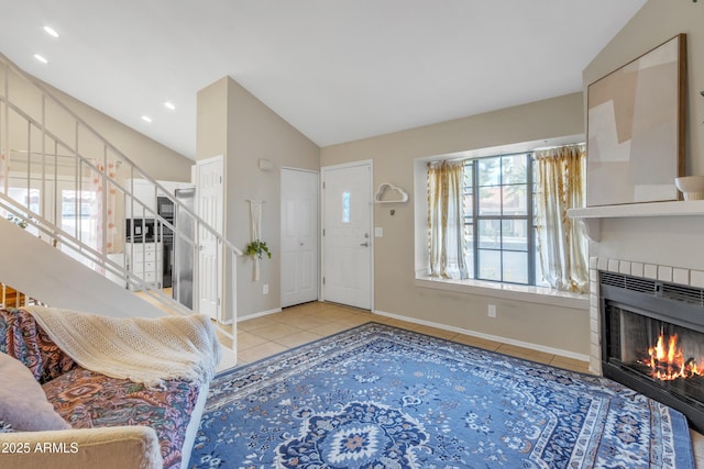 tiled foyer with lofted ceiling, a fireplace, stairway, and baseboards