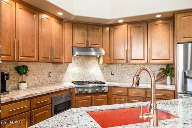 kitchen featuring light stone countertops, appliances with stainless steel finishes, and decorative backsplash