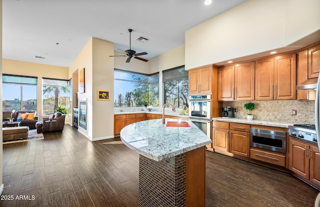 kitchen with sink, stainless steel appliances, a center island, ceiling fan, and dark hardwood / wood-style flooring