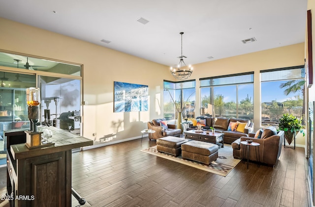 interior space with dark wood-type flooring and ceiling fan with notable chandelier