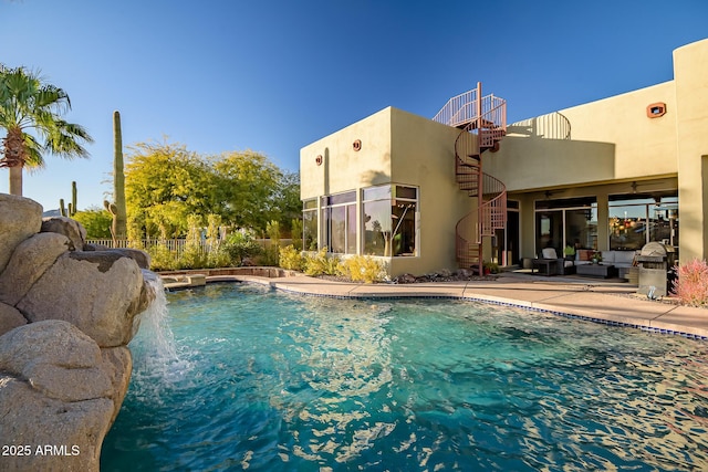 view of swimming pool with pool water feature and a patio area