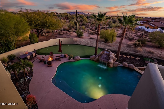 pool at dusk featuring a fire pit