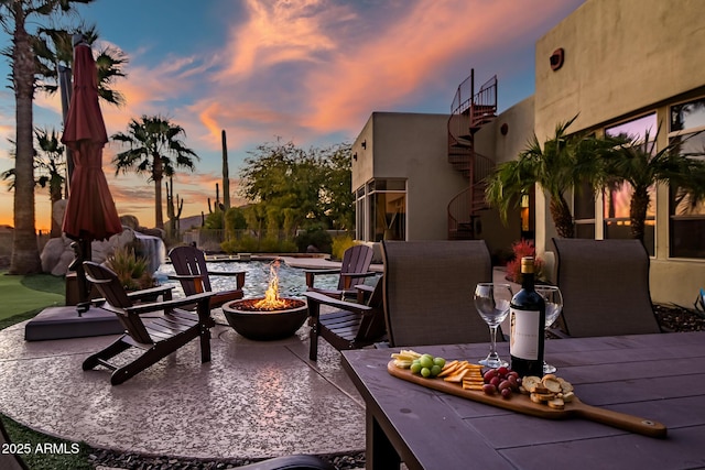 patio terrace at dusk featuring a fire pit