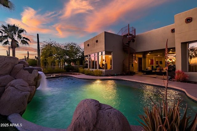 pool at dusk featuring a patio area