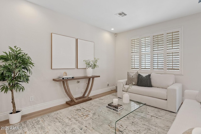 living area with recessed lighting, wood finished floors, visible vents, and baseboards