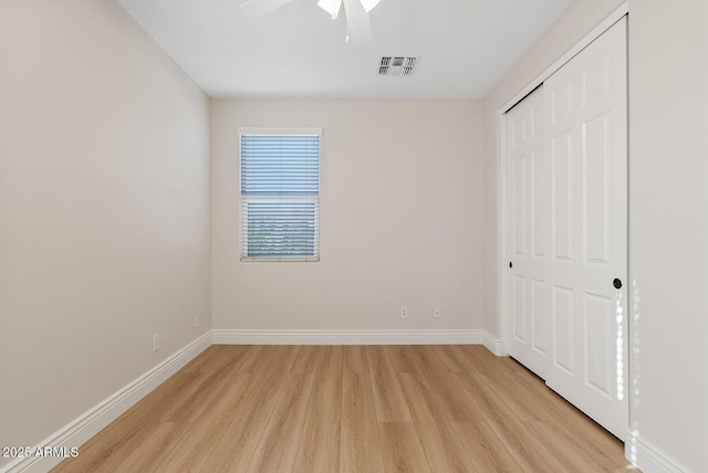 unfurnished bedroom with light wood finished floors, a closet, visible vents, and baseboards