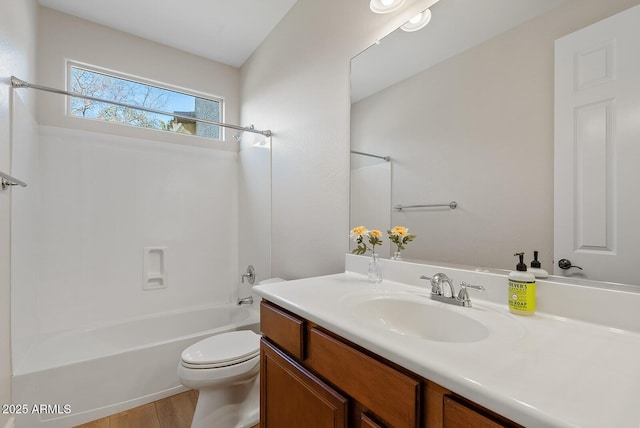 bathroom featuring wood finished floors, vanity, toilet, and shower / bathtub combination