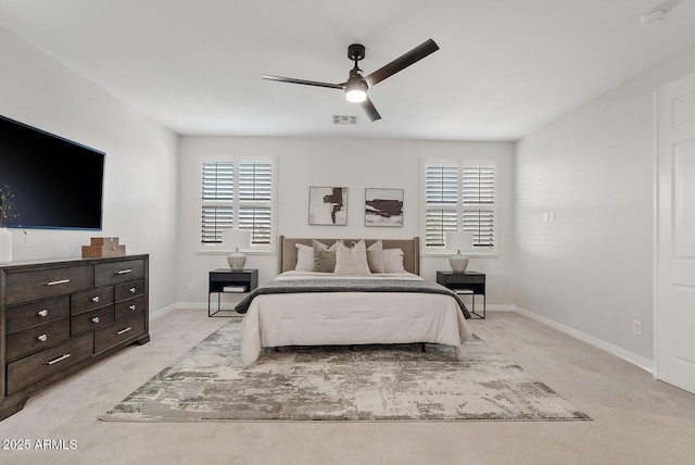 bedroom with light colored carpet, visible vents, baseboards, and multiple windows