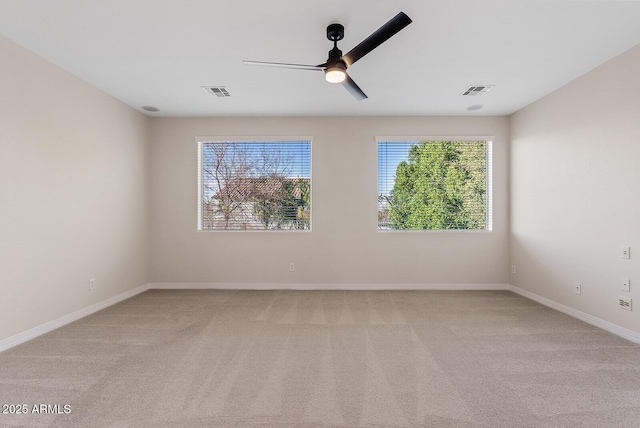 empty room featuring baseboards, visible vents, a ceiling fan, and light colored carpet