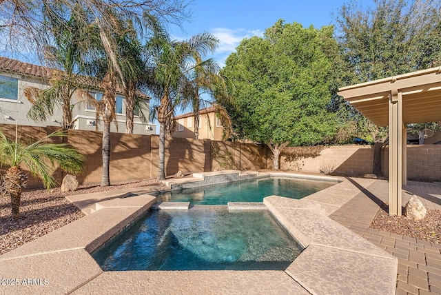 view of swimming pool featuring a fenced backyard, a pool with connected hot tub, and a patio