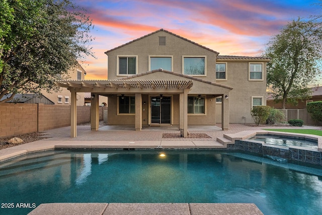 back of house at dusk with a patio, a pergola, a fenced backyard, and stucco siding