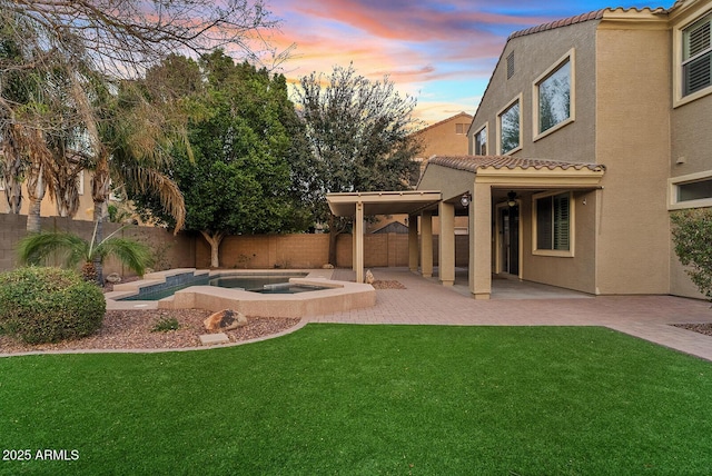 view of yard with a patio area, a fenced backyard, and an in ground hot tub