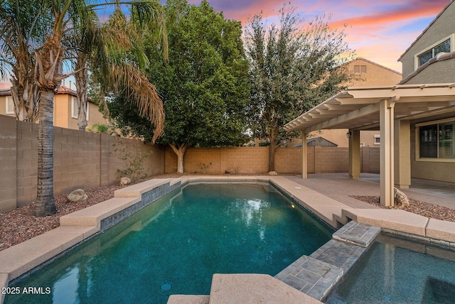 pool at dusk with a patio area, a fenced backyard, and a fenced in pool