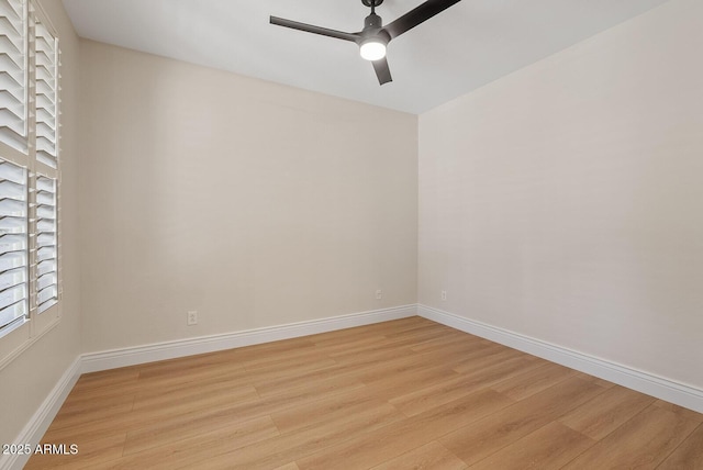 spare room featuring a ceiling fan, light wood-type flooring, and baseboards