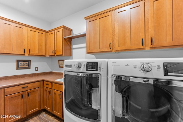 washroom with cabinets, washing machine and clothes dryer, and dark hardwood / wood-style flooring