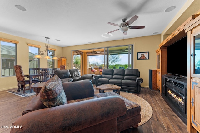 living room featuring dark wood-type flooring and ceiling fan