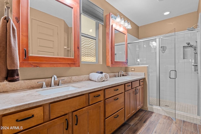 bathroom featuring a shower with door, vanity, and wood-type flooring