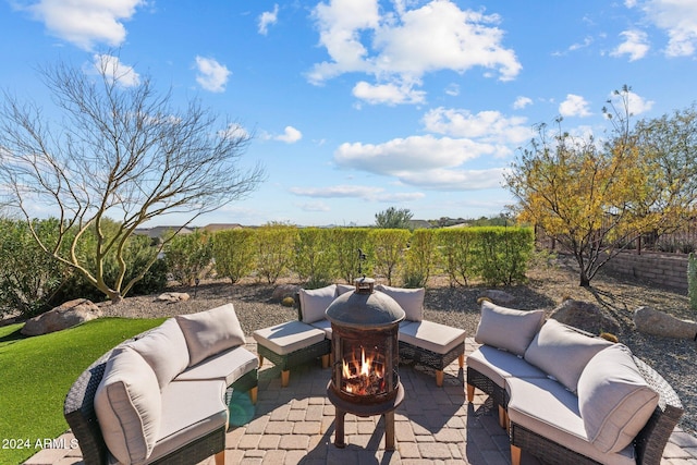 view of patio with an outdoor living space with a fire pit