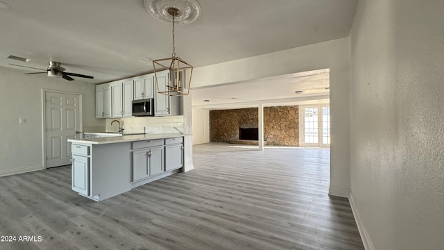 121 E Monte Way, Phoenix, AZ 85042 - kitchen with stainless steel microwave, open floor plan, baseboards, wood finished floors, and a textured wall