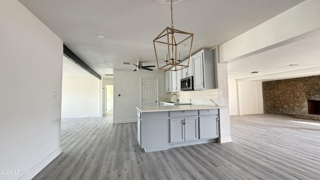 121 E Monte Way, Phoenix, AZ 85042 - kitchen featuring open floor plan, stainless steel microwave, gray cabinetry, light wood-style floors, and light countertops