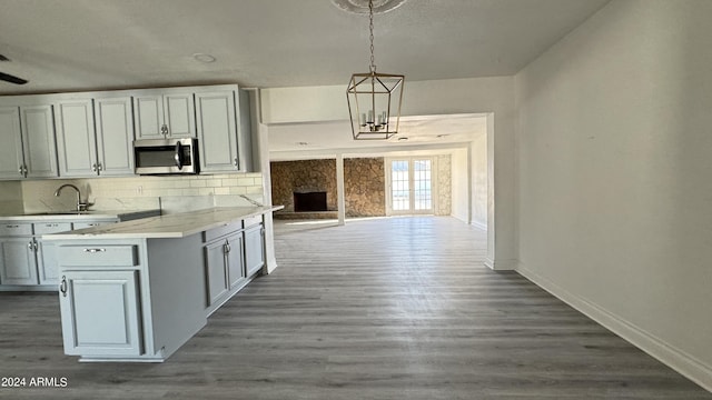 121 E Monte Way, Phoenix, AZ 85042 - kitchen with stainless steel microwave, a sink, baseboards, tasteful backsplash, and dark wood-style flooring