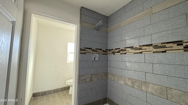 121 E Monte Way, Phoenix, AZ 85042 - bathroom featuring toilet, a tile shower, and baseboards