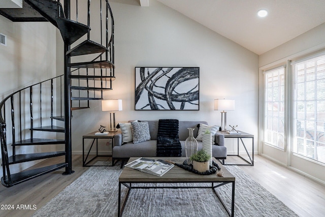 living area featuring stairs, plenty of natural light, and wood finished floors