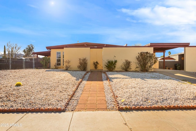 view of front of house with fence and stucco siding