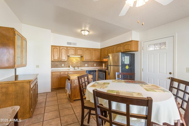 kitchen with tasteful backsplash, visible vents, stainless steel appliances, light countertops, and a sink