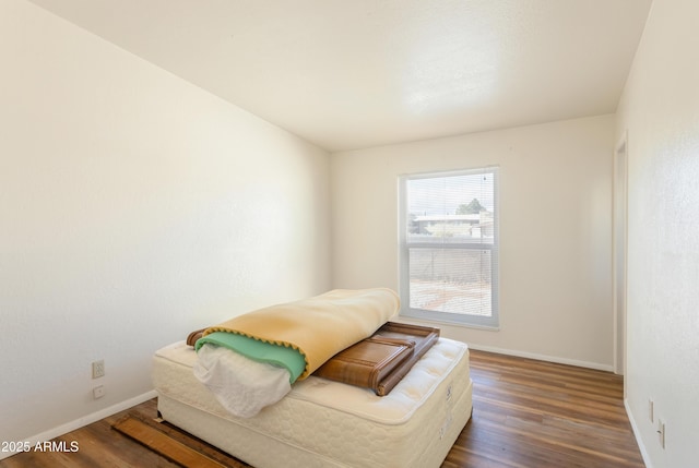 bedroom with baseboards and wood finished floors