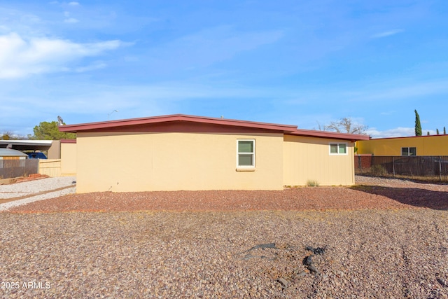 view of side of home featuring fence