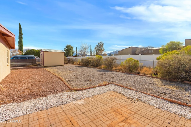 view of yard featuring a patio, a shed, an outdoor structure, and fence